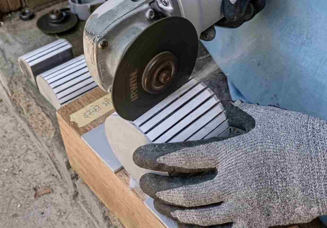 Cutting the light design on PVC pipe with an angle grinder